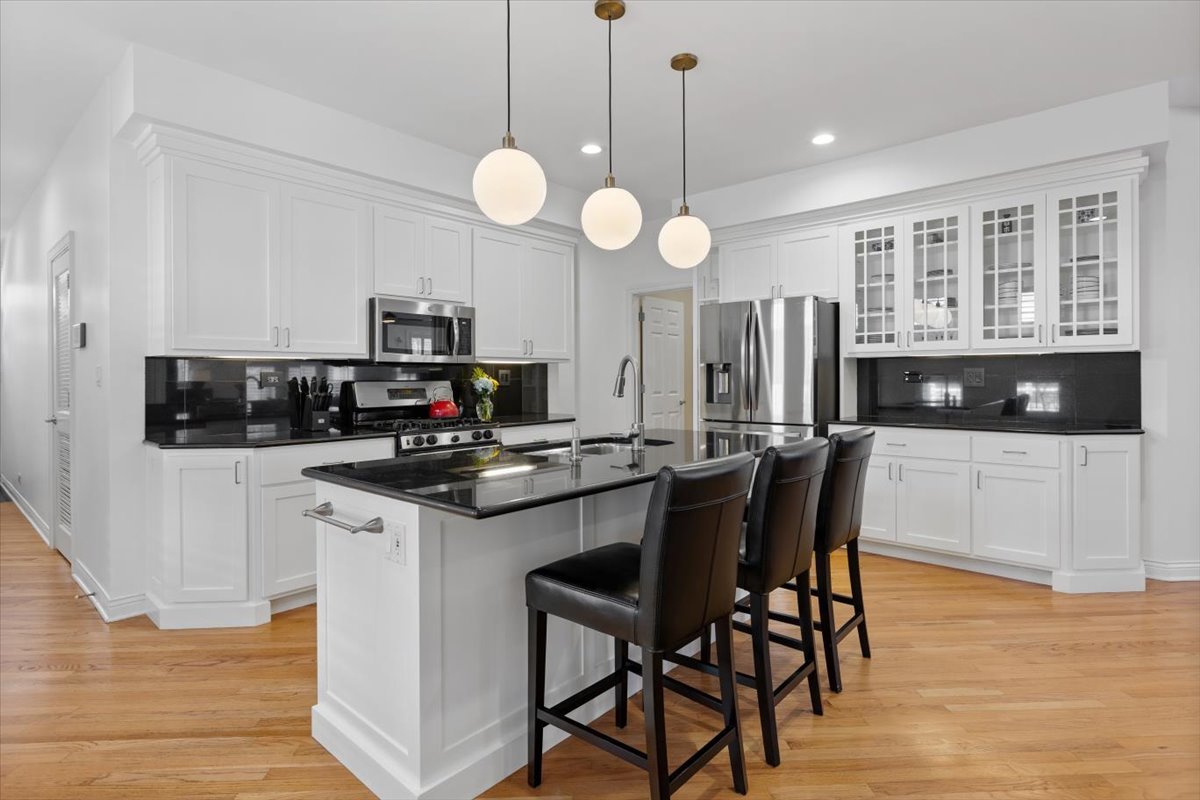 1249 North Wolcott Avenue, Unit 2 Chicago, IL 60622 - Photo 11 of 26 a kitchen with stainless steel appliances a stove a microwave a center island and a refrigerator
