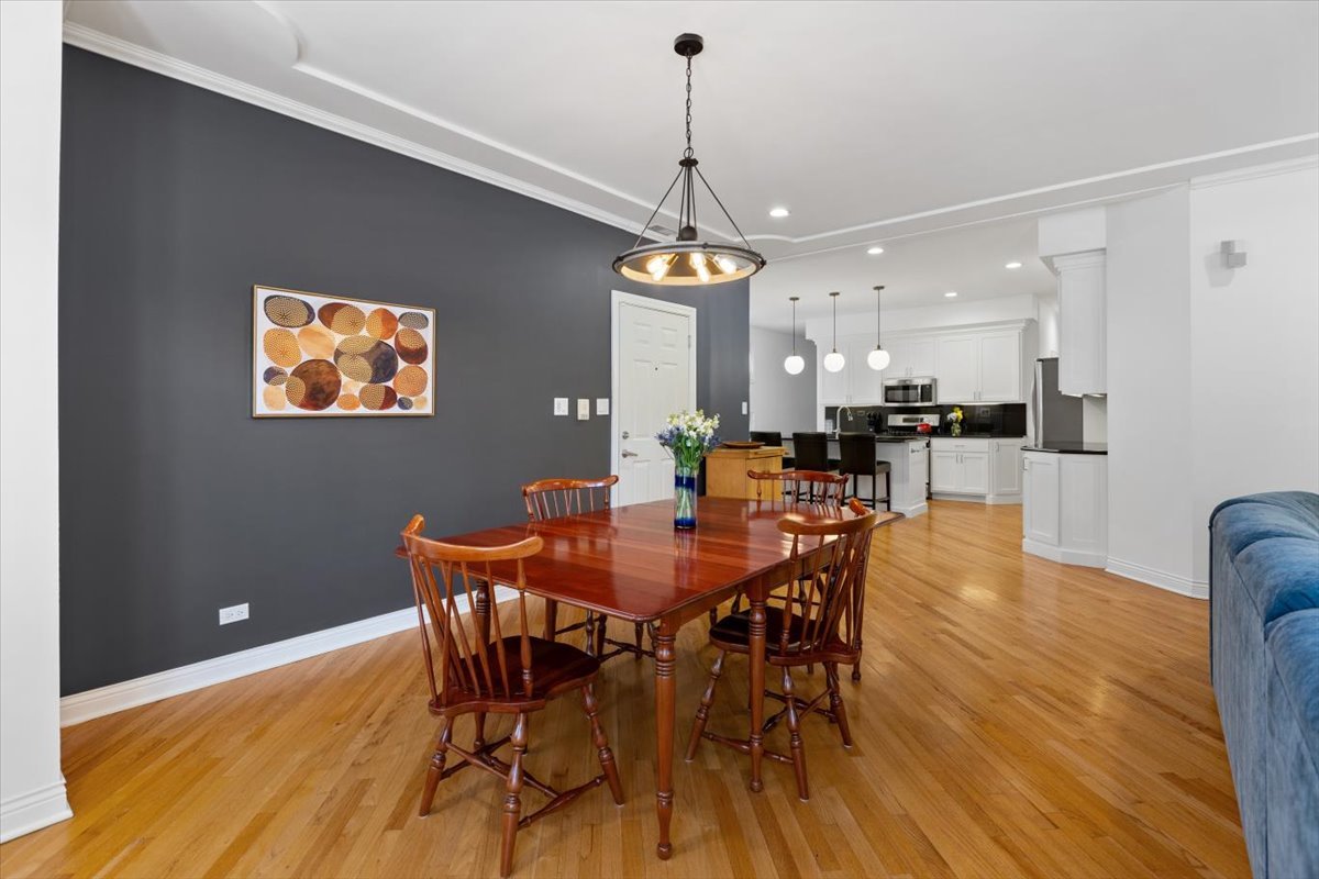 1249 North Wolcott Avenue, Unit 2 Chicago, IL 60622 - Photo 7 of 26 a dining room with furniture a chandelier and wooden floor