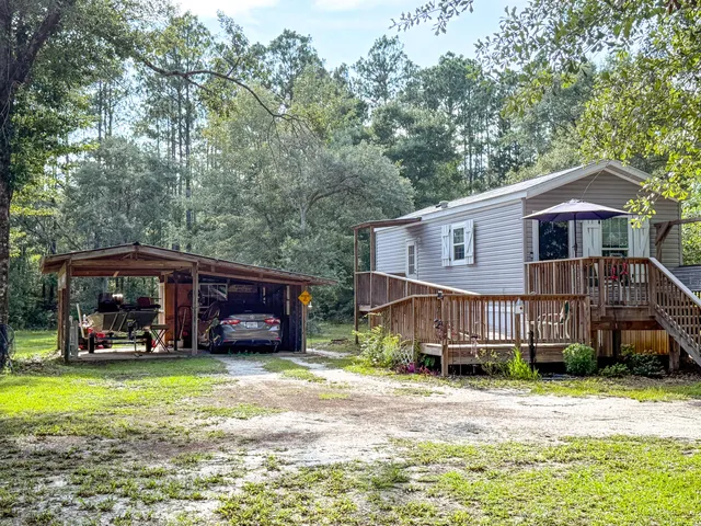 a view of a house with a yard and sitting area