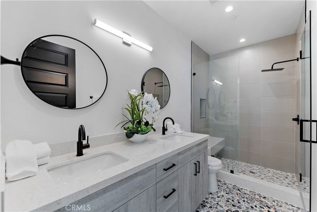 a bathroom with a sink a toilet and a mirror