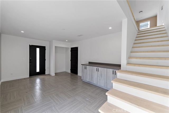 a large kitchen with stainless steel appliances kitchen island granite countertop a sink stove and refrigerator