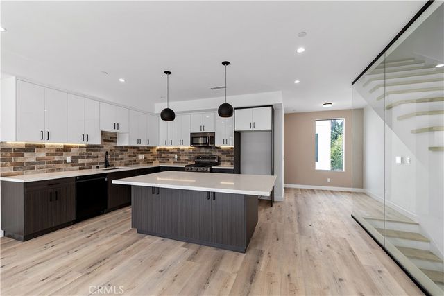 a kitchen with a stove a counter space and wooden floor