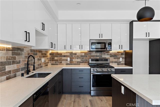 a kitchen with stainless steel appliances a stove top oven and cabinets