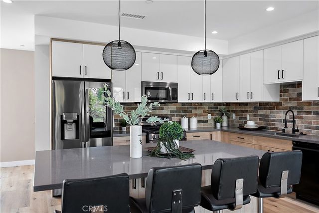 a living room with lots of furniture and kitchen view