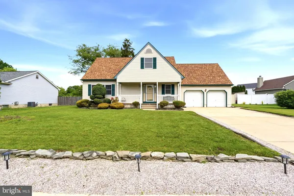 a front view of a house with a garden and trees