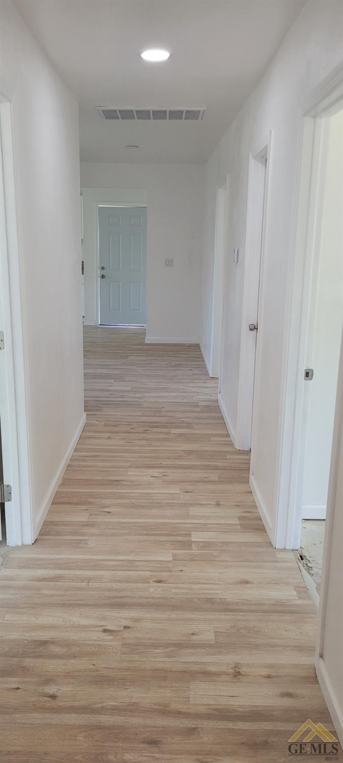 Undisclosed Address Bakersfield, CA 93308 - Photo 3 of 15 a view of an empty room with wooden floor