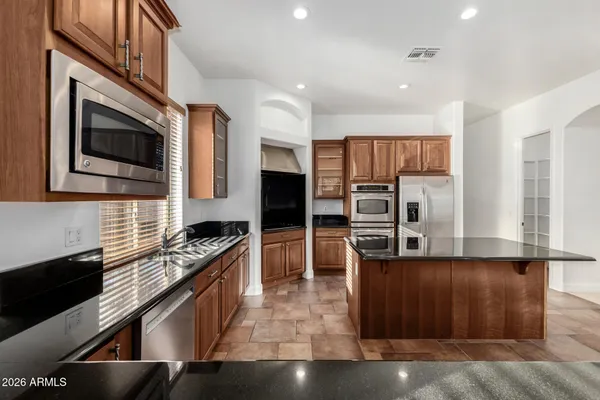 a kitchen with stainless steel appliances granite countertop a stove a sink dishwasher a refrigerator and a microwave