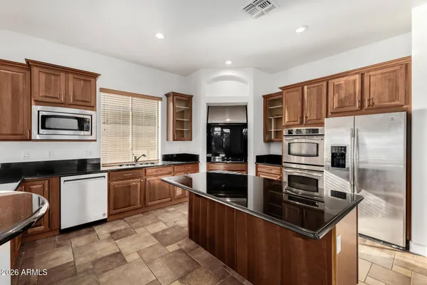 a kitchen with stainless steel appliances a sink a stove and a refrigerator