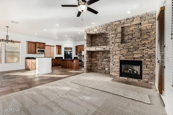 a living room with furniture a fireplace and a ceiling fan