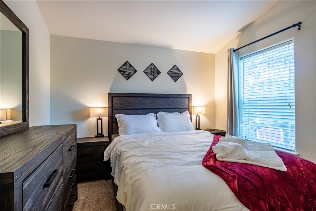 5038 Oak Road Midpines, CA 95345 - Photo 24 of 53 a bedroom with a bed and a dresser next to a window
