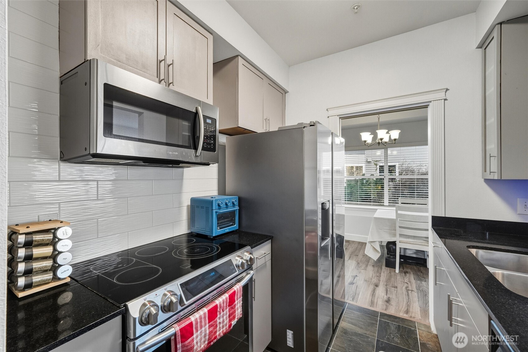 255 West Bakerview Road, Unit B103 Bellingham, WA 98226 - Photo 10 of 40 a kitchen with stainless steel appliances granite countertop a stove a microwave and a refrigerator