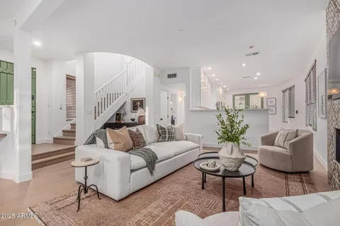 a living room with furniture a flat screen tv and a fireplace