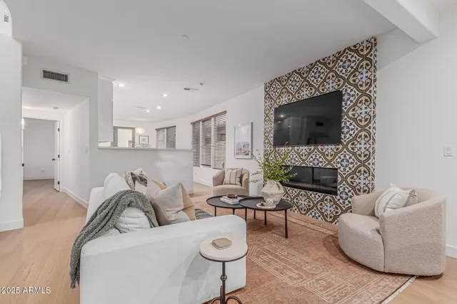 a living room with furniture a flat screen tv and a fireplace
