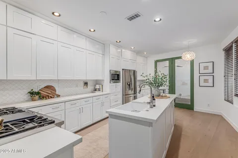 a kitchen with white cabinets and stainless steel appliances
