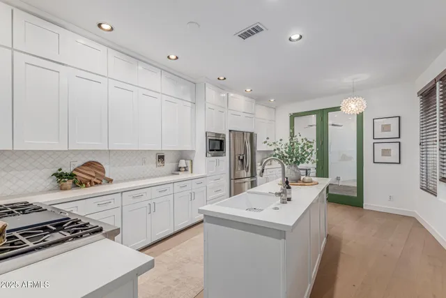 a kitchen with white cabinets and stainless steel appliances