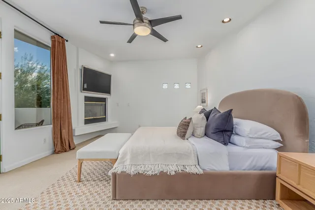 a bedroom with a large bed chandelier and a window