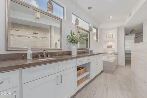 a bathroom with a double vanity sink a large mirror and shower
