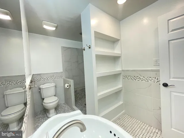 a bathroom with a toilet and a shower