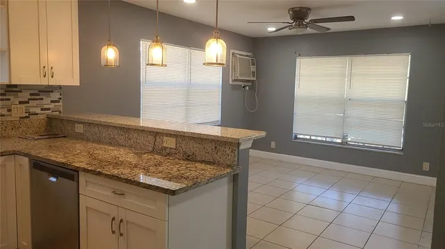 a bathroom with a granite countertop sink a mirror and a shower