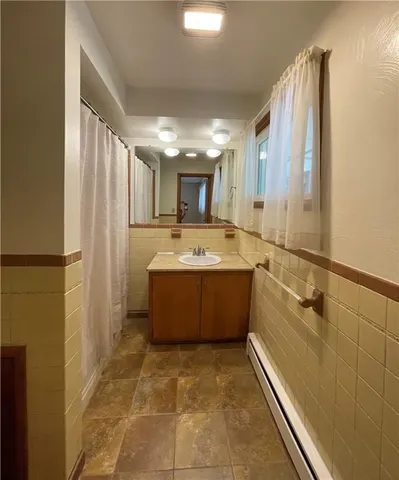 a bathroom with a tub sink and mirror