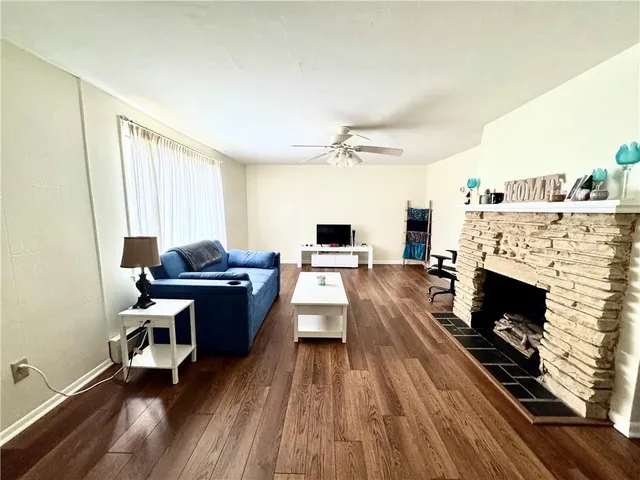 a living room with furniture a fireplace and a flat screen tv