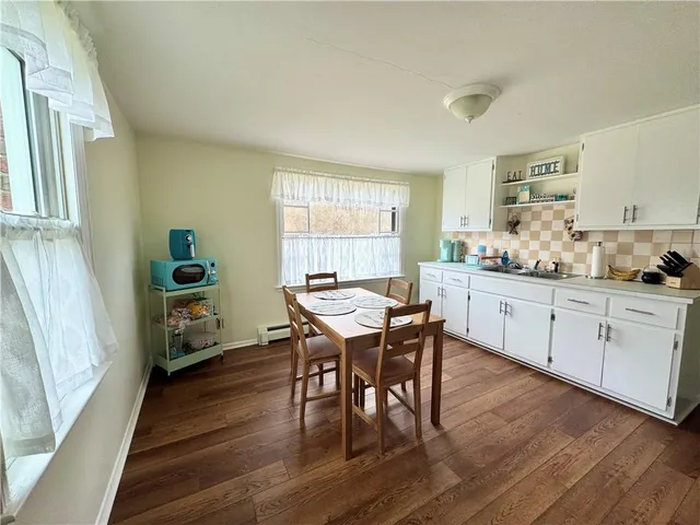 a kitchen with a dining table chairs and white cabinets