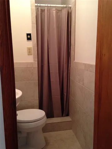a bathroom with a toilet and a shower curtain