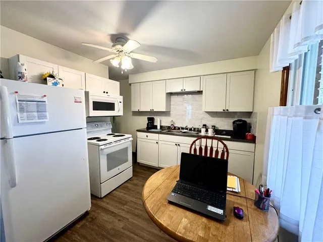 a kitchen with a refrigerator cabinets and white appliances
