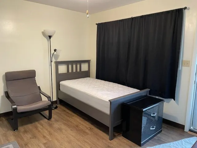 a bedroom with a bed and a chair