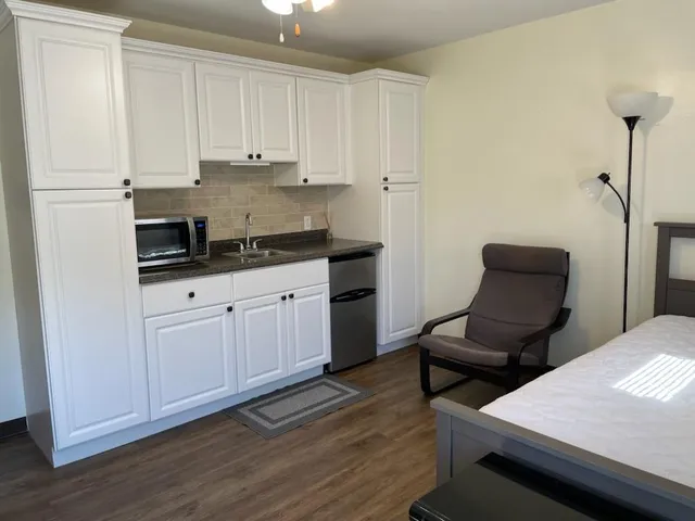 a kitchen with granite countertop white cabinets and white appliances