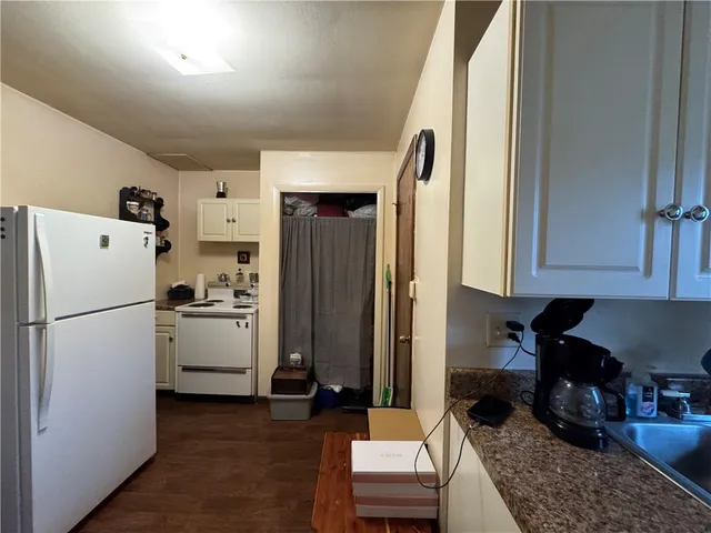 a kitchen with a refrigerator a stove and a cabinets with wooden floor
