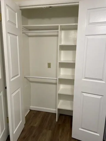 a view of walk in closet with empty racks