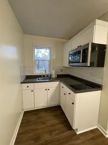 a kitchen with granite countertop cabinets stainless steel appliances a sink and a window