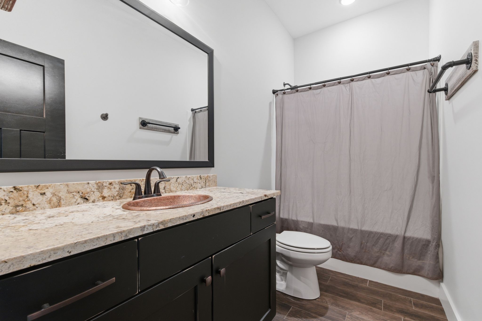 4041 Liverworth Road Southside, TN 37171 - Photo 33 of 63 a bathroom with a granite countertop sink toilet a mirror a vanity and shower