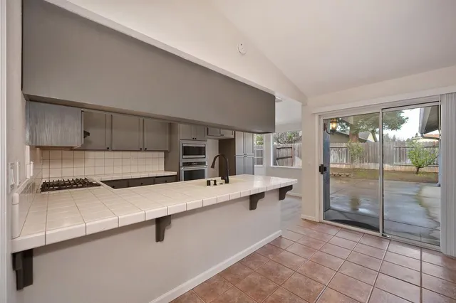 a large white kitchen with a sink and refrigerator