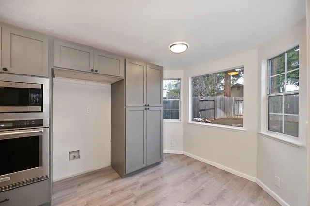 a view of a kitchen with wooden floor and electronic appliances
