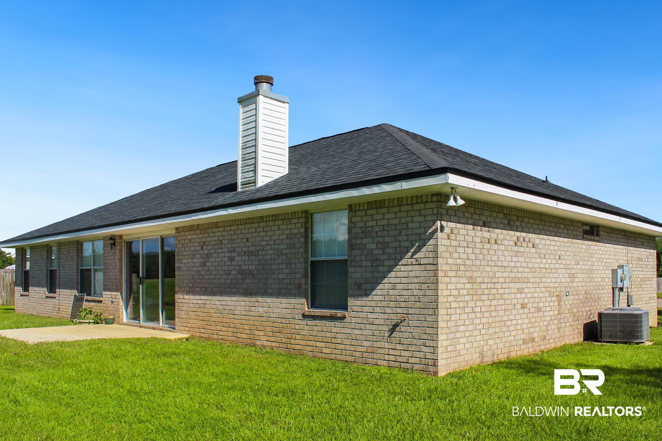 14750 Pawnee Court Foley, AL 36535 - Photo 31 of 34 Rear view of property with a lawn, brick siding, a chimney, and roof with shingles
