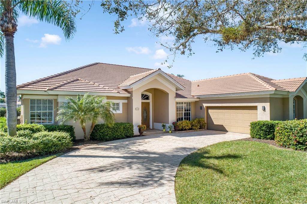 8931 Lely Island Circle Naples, FL 34113 - Photo 1 of 46 a front view of a house with a yard and potted plants