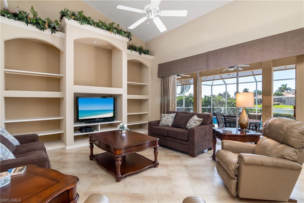 8931 Lely Island Circle Naples, FL 34113 - Photo 11 of 46 a living room with furniture flat screen tv and a large window