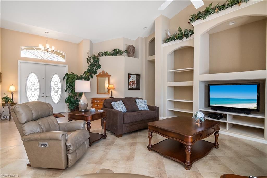 8931 Lely Island Circle Naples, FL 34113 - Photo 12 of 46 a living room with furniture and a flat screen tv