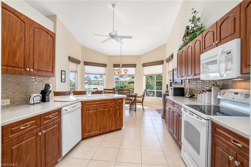 8931 Lely Island Circle Naples, FL 34113 - Photo 19 of 46 a kitchen with stainless steel appliances granite countertop a sink and cabinets