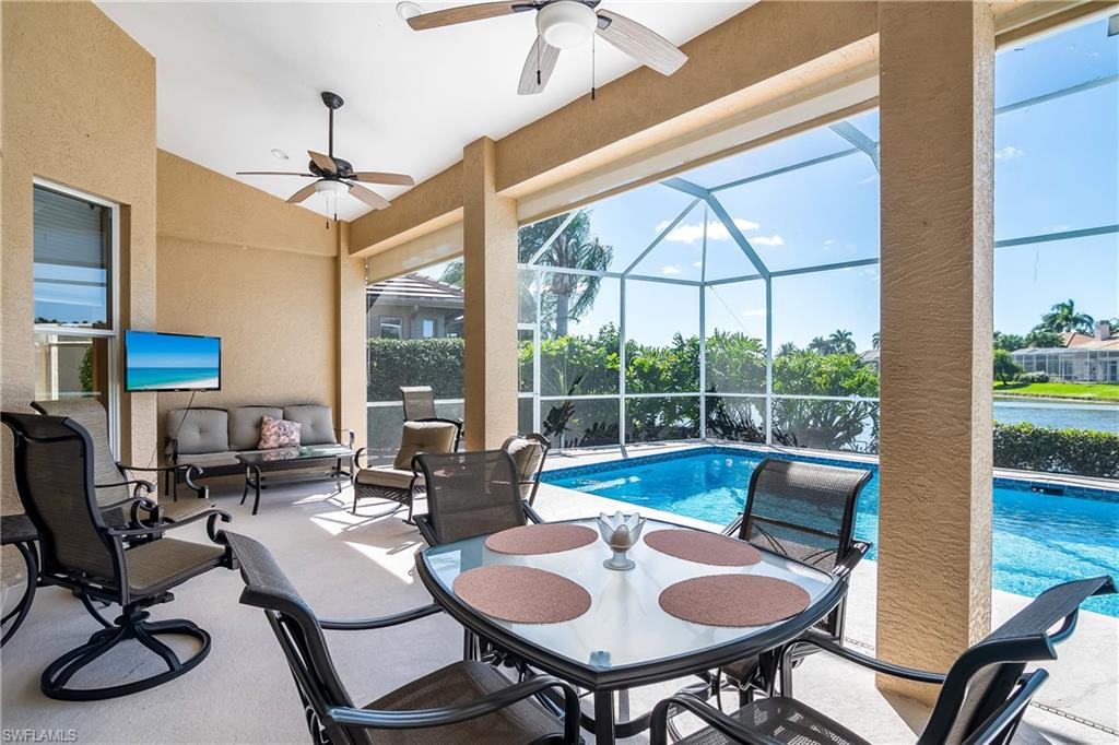 8931 Lely Island Circle Naples, FL 34113 - Photo 31 of 46 a view of a dining room with furniture wooden floor and a chandelier