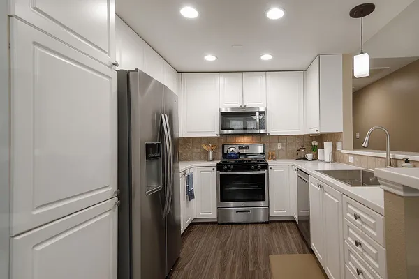 a kitchen with a sink stainless steel appliances and cabinets