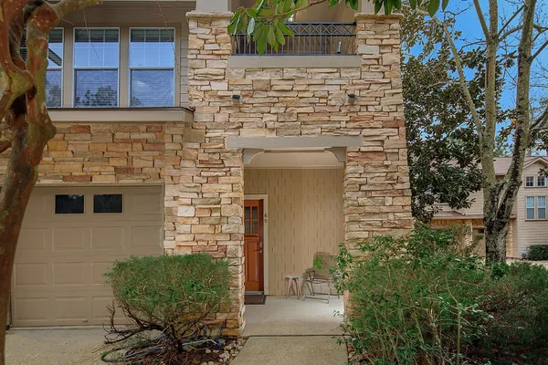 a brick building with a bench and potted plants