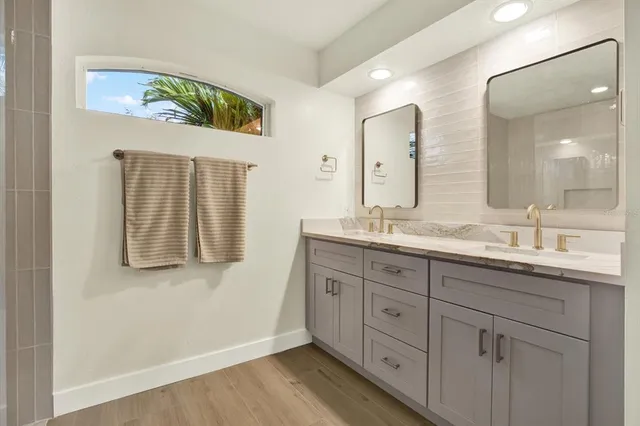 a bathroom with a granite countertop double vanity sink and mirror