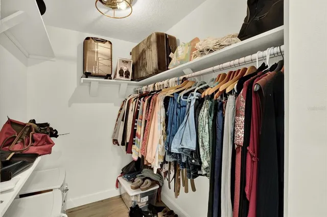 a view of walk in closet with clothes and shoes