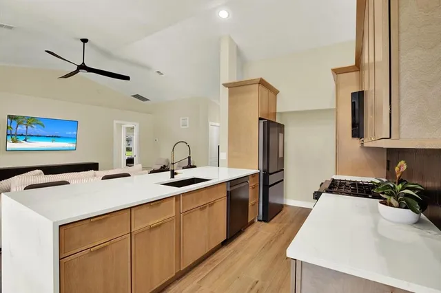 a kitchen with stainless steel appliances a sink stove and refrigerator