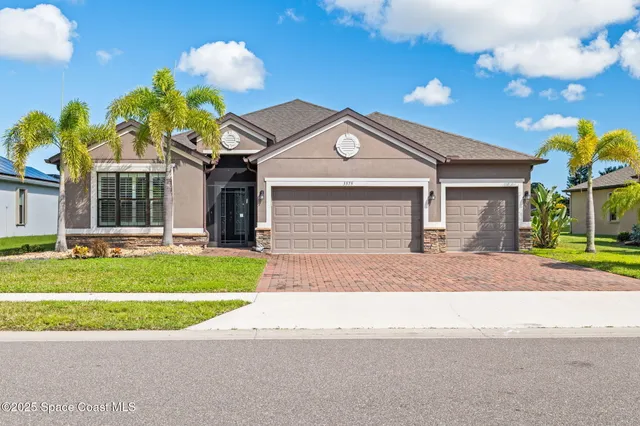a front view of a house with a garden and garage