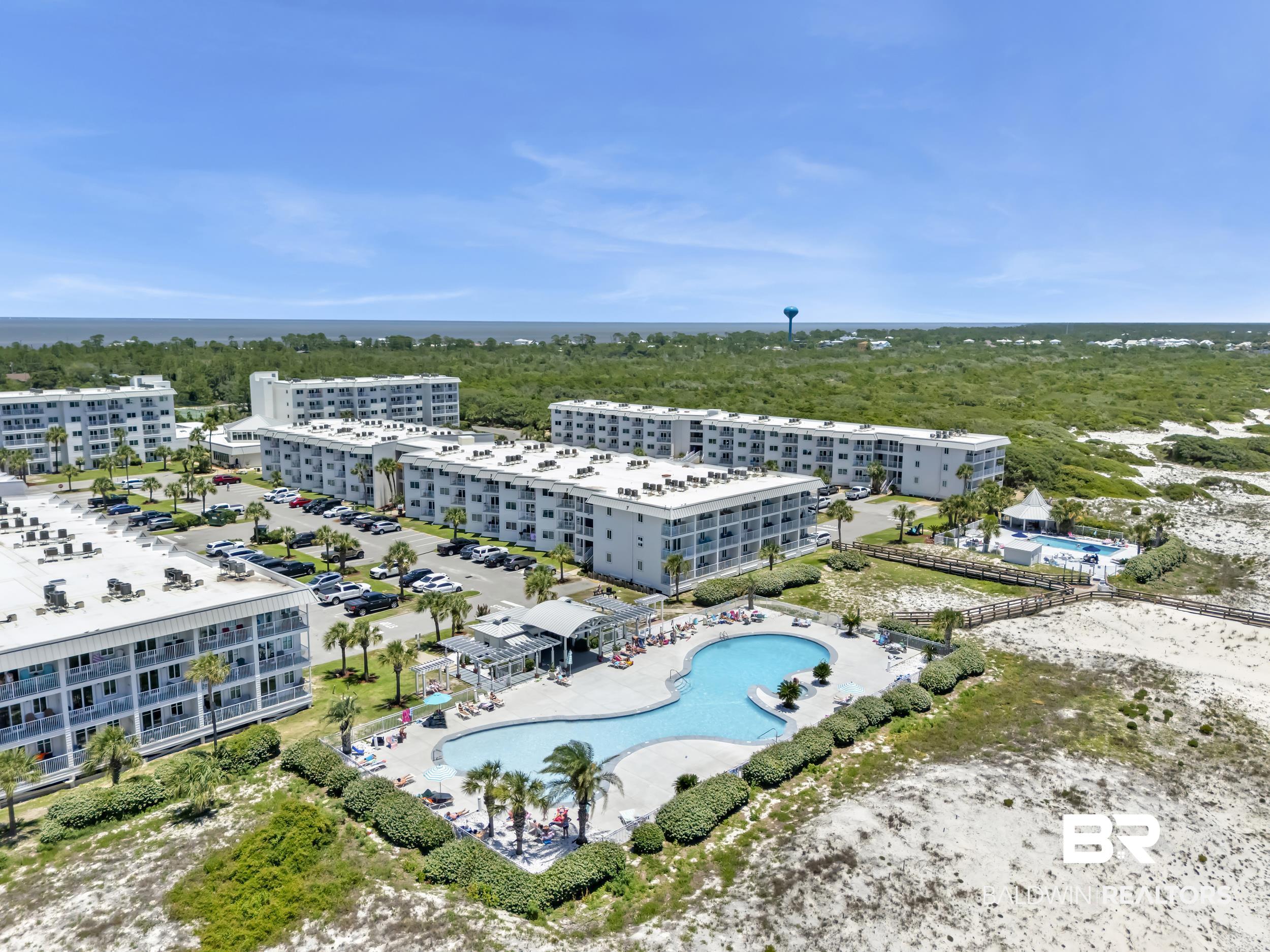 400 Plantation Road, Unit 2118 Gulf Shores, AL 36542 - Photo 46 of 59 Coastal property featuring multiple white residential buildings with private balconies, surrounded by sandy terrain and lush greenery