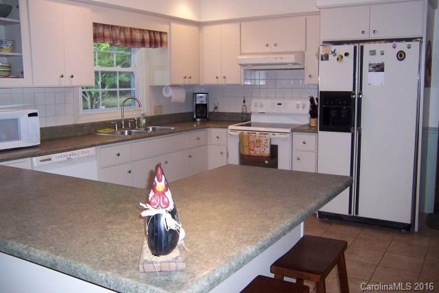 2316 Golf Course Road, Unit P8871 & P88151 Columbus, NC 28722 - Photo 17 of 21 a kitchen with stainless steel appliances granite countertop a refrigerator sink and white cabinets